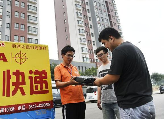 刘钊(中)和孙文泰在电商园通过快递为顾客发货
