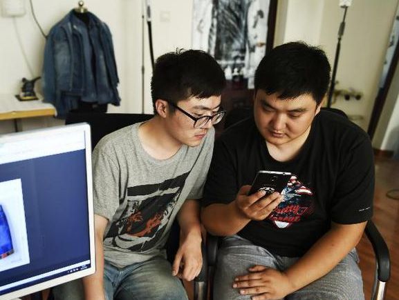 孙文泰(右)和刘钊在工作室查看推送的微店信息